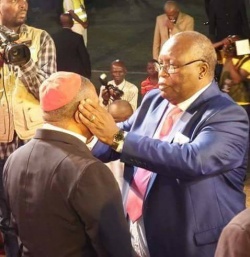 Baruti prays for bishop.JPG